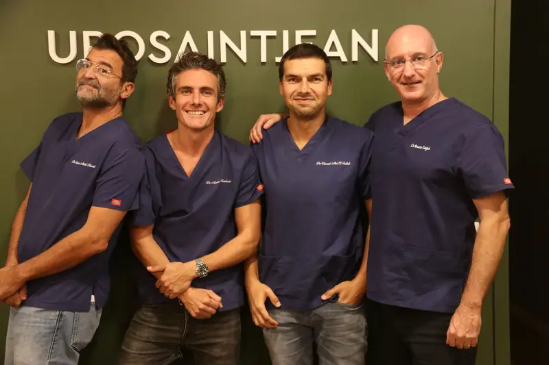 Les quatre chirurgiens urologues d’URO Saint-Jean devant le mur du cabinet